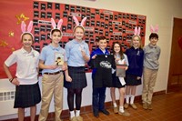 four female students wearing bunny ears and three male students with two wearing bunny ears and one holding a book